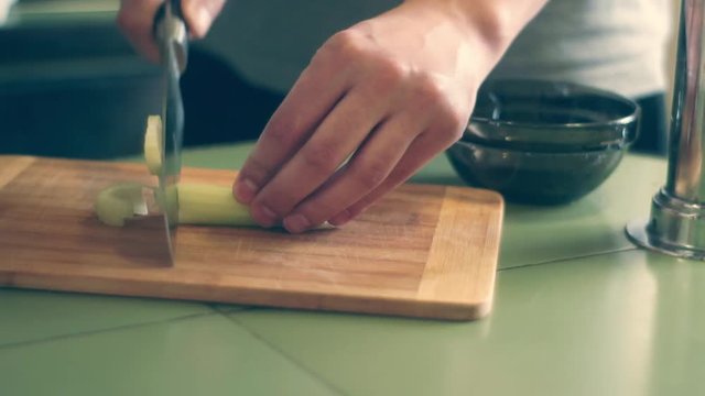 slice the celery with a knife male hand home cooking