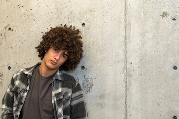 Portrait of teenage boy by concrete wall