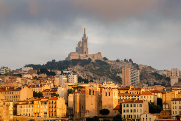 Fototapeta premium Panoramic cityscape of Marseille with the church Notre-Dame de la Garde, landmark of the city, on a hilltop. Marseille, Provence, France. Holidays in France.