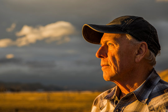 Senior man in baseball cap at sunset