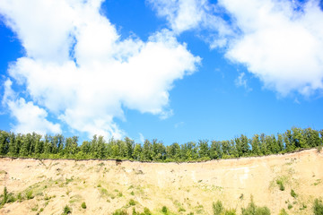 Beautiful summer landscape, sandy beach, river, blue sky and white big clouds.