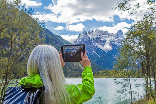 Woman photographing with digital tablet Tre Cime di Lavaredo, Italy