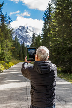 Man photographing with digital tablet at Tre Cime di Lavaredo, South Tyrol