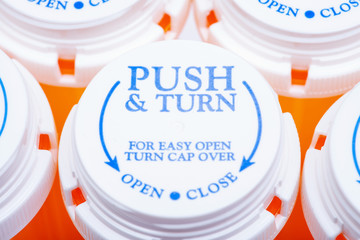 Orange plastic empty prescription containers with Child-Resistant Push&Turn Cap. Top view.