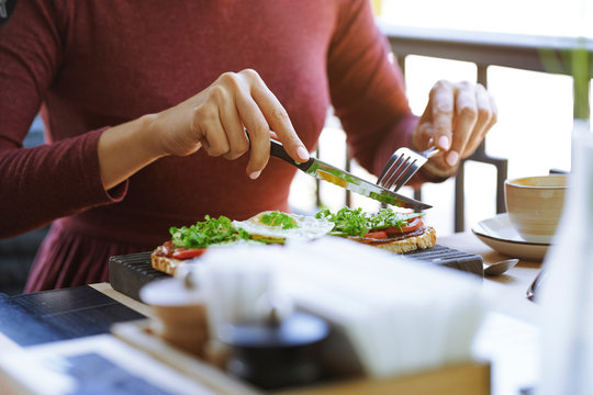 Hands of woman eating lunch at cafe