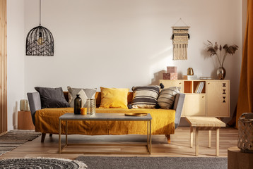 Fashionable living room interior with yellow and grey design and long coffee table in the middle