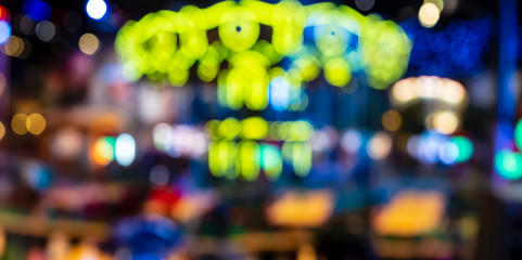 Blurred multicolored lights of the carousel in the night park look like a skeleton skull suitable...