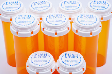 Orange plastic empty prescription containers with Child-Resistant Push&Turn Cap. Top view.