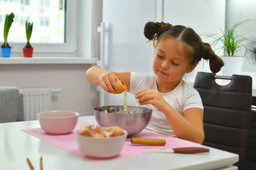 Little girl preparing cookies in kitchen at home. Cooking homemade food.