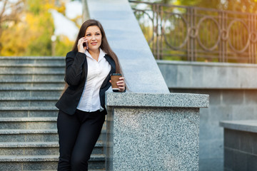 Businesswoman talking on phone while walking outdoor