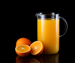 orange, orange juice in a jug on a black background
