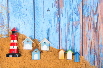 Lighthouse and beach huts in sand
