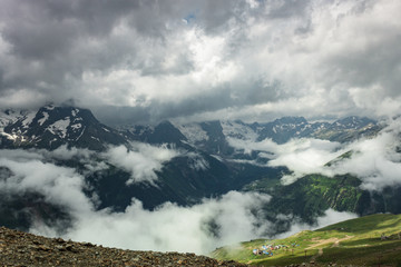 summer mountains green grass snow and stormy sky landscape