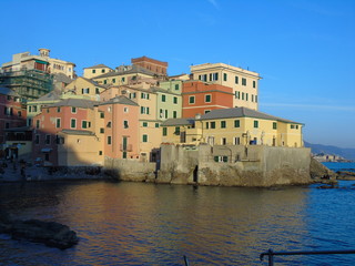 Fototapeta premium Genova, Italy - 02/14/2019: An amazing caption of the sunset over the sea and the city of Genoa in winter days and great views to the old buildings near the beach coloured by the sun