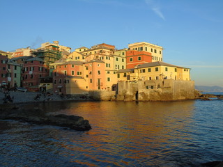 Genova, Italy - 02/14/2019: An amazing caption of the sunset over the sea and the city of Genoa in winter days and great views to the old buildings near the beach coloured by the sun