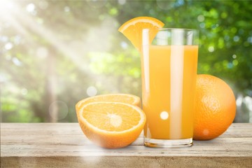 Glass of delicious orange juice on table