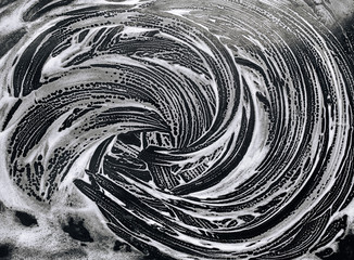 White foam and soap on black background. Abstract pattern. The concept of washing oily brazier or...