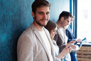 The connected team is an efficient team. Group of businesspeople using wireless technology together...