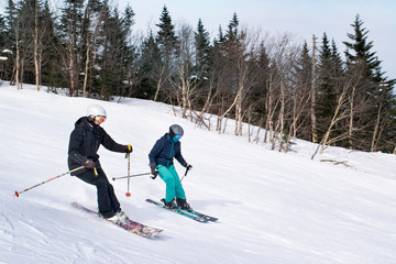 Women skiers downhill ski together on the slopes