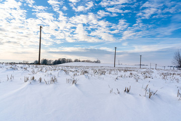 Empty Countryside Landscape in Sunny Winter Day with Snow Covering the Ground with Power Lines in Frame, Abstract Background with Deep Look