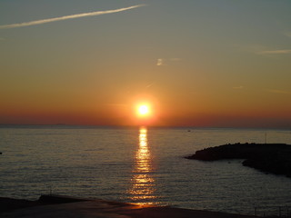 Genova, Italy - 02/14/2019: An amazing caption of the sunset over the sea and the city of Genoa in winter days and great views to the old buildings near the beach coloured by the sun
