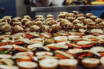 Closeup View of Sliced Bread Spread on the Table with Ingredients on them for Small Burgers - Kitchen Set, Concept of the Holiday Evening Dinner Table