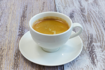 white Cup of coffee on a wooden table close-up. black coffee with milk. wooden table with a fragrant drink.