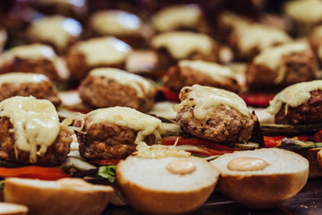 Closeup View of Sliced Bread Spread on the Table with Ingredients on them for Small Burgers - Kitchen Set, Concept of the Holiday Evening Dinner Table