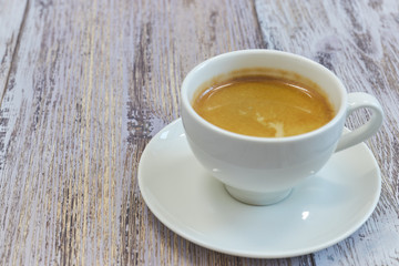 white Cup of coffee on a wooden table close-up. black coffee with milk. wooden table with a fragrant drink.