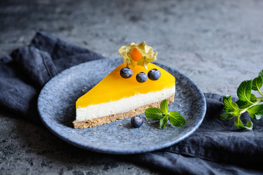 No bake mango cheesecake decorated with blueberries and physalis