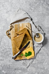 Grilled sandwiches with cheese turn, black bread, Turkey meat and arugula. Gray background, top view, space for text