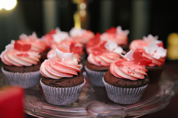  Close up of chocolate cupcakes with meringue cream and fruit. Candy bar at a party. Selective focus.
