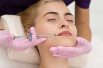 Crop of woman face with closed eyes lying on couch during lifting procedure in spa salon in professional. Attractive blonde caring about her face skin and receiving injection. Concept of beauty.