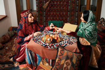Beautiful azeri women and novruz tray with traditional pastry shekerbura and pakhlava