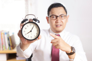 Asian Businessman Pointing at Clock, Angry Expression