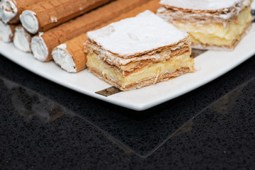 Party platter with arranged sweet desserts from a bakery on banquet table at business or wedding event venue. Sweet food, buffet. Unhealthy food. 