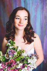 Cute bride with a bouquet of flowers on a multi-colored background