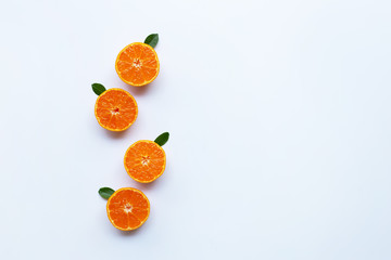 Orange fruits and green leaves on a white background.
