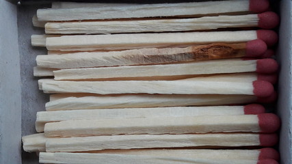 row of match sticks with red heads. Red head matches in a white opened box on white background