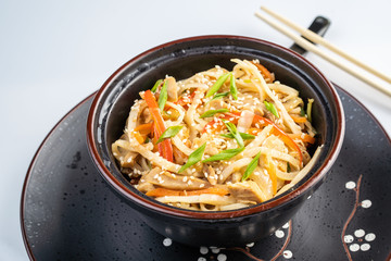 Japanese ramen soup with chicken, egg, chives and sprout on dark wooden background.