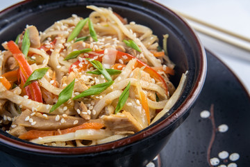 Japanese ramen soup with chicken, egg, chives and sprout on dark wooden background.
