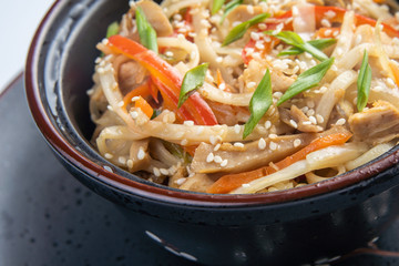Japanese ramen soup with chicken, egg, chives and sprout on dark wooden background.