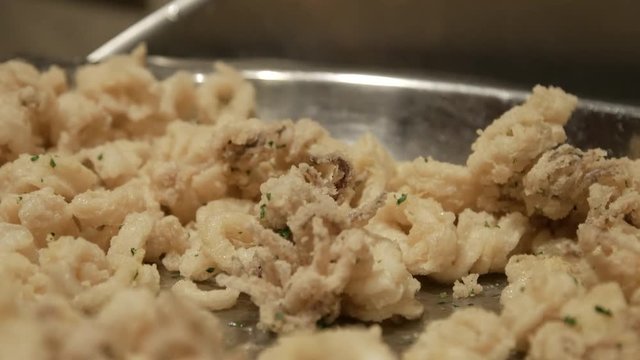 Close up of calamari bing served with spoon