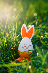 Young Boy in blue shirt holds wooden basket with hand painted eggs in hands at sunlight in spring garden. Egg hunt, spring festive background, decoration for Easter