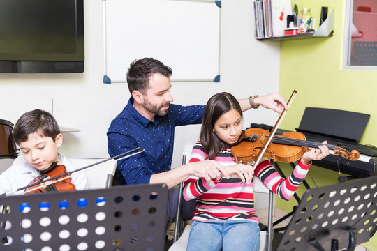 Cute Children Learning To Play Violin In Class