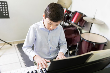 Talented Kid Playing Sound Synthesizer In Music School