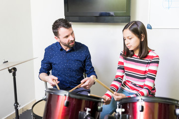 Trainer Teaching Drum Playing Technique To Girl