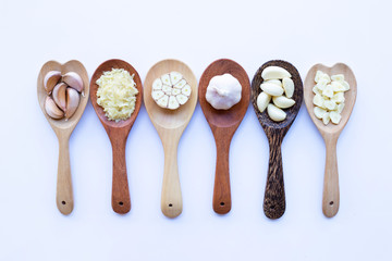 Garlic on wooden spoon on white