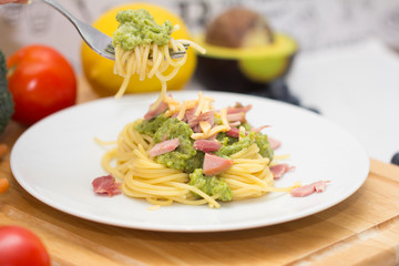 Spaghetti with fish and pesto sauce on white plate . Traditional italian cuisine.