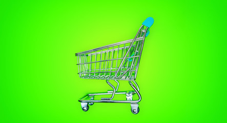 Miniature shopping cart isolated on green